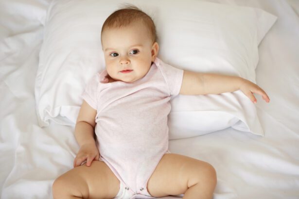 Portrait of cute nice little baby girl lying on pillow in bed. From above.