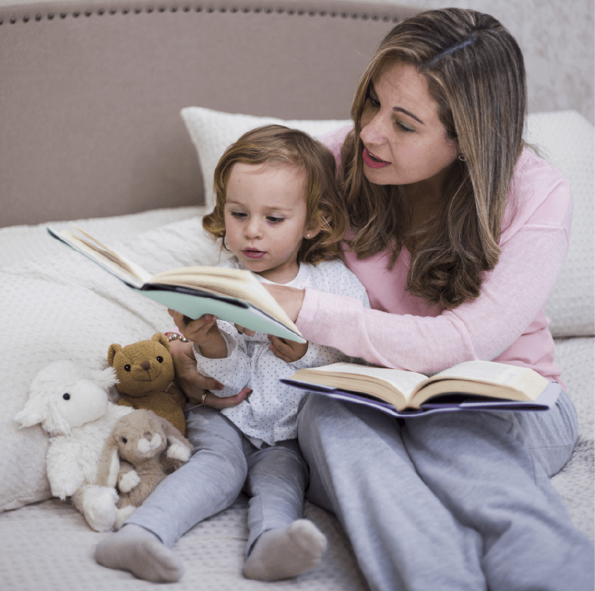 A parent reading a story, with kids listening intently in their PJs