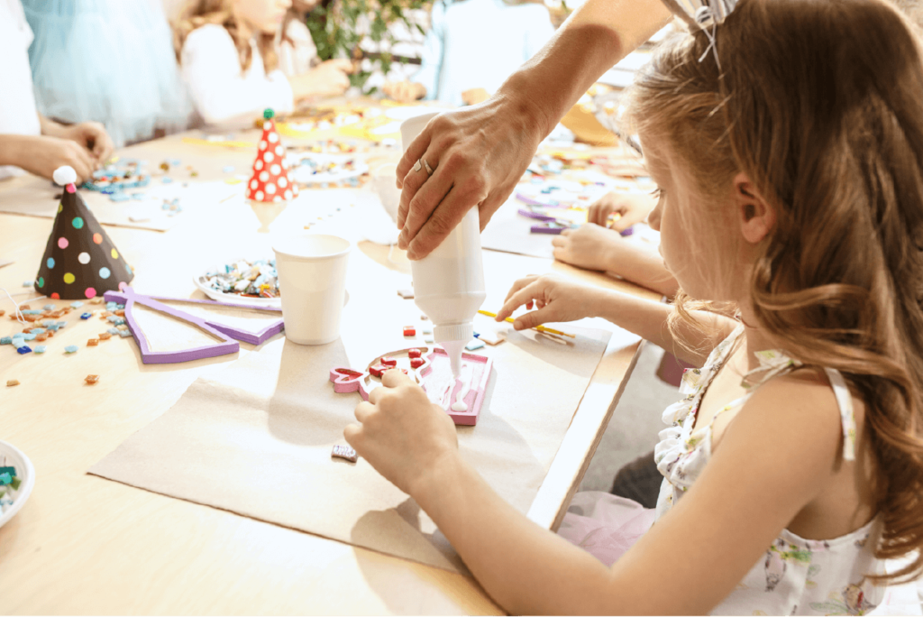 Kids busy crafting, surrounded by colorful beads and materials