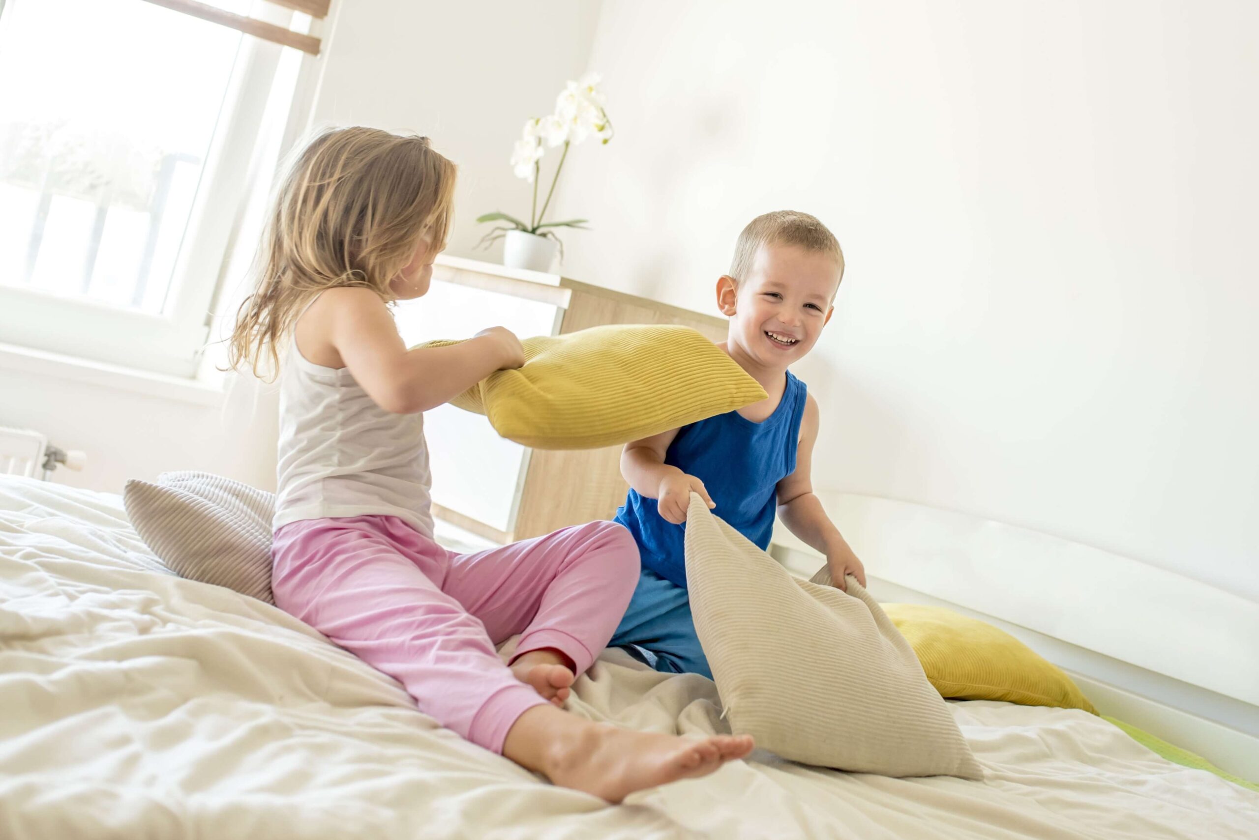 Kids having a pillow fight, giggling away