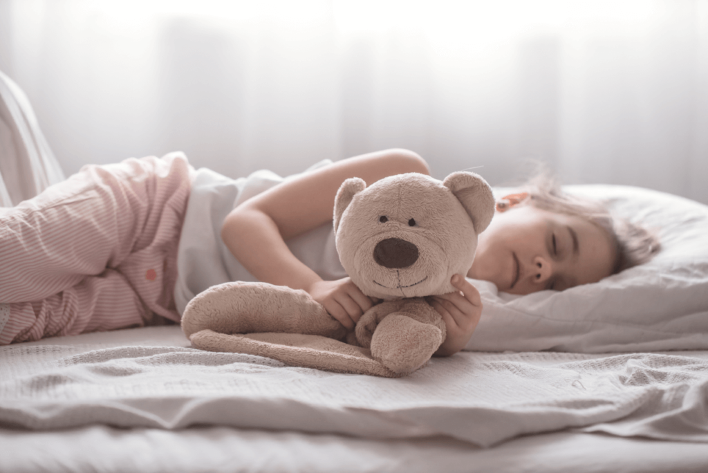 Kids sleeping peacefully, surrounded by stuffed toys