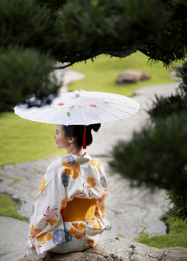 A Japanese child in a colorful Yukata with cherry blossom motifs