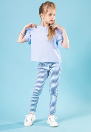 A celebrity child donning blue and white striped pajamas with a fun graphic on the pocke