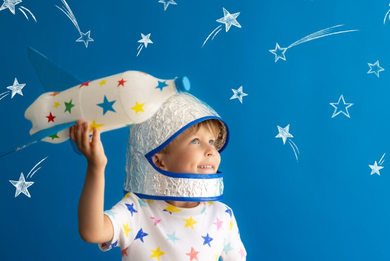 A-child-in-star-patterned-pajamas-gazing-at-a-book-about-constellation