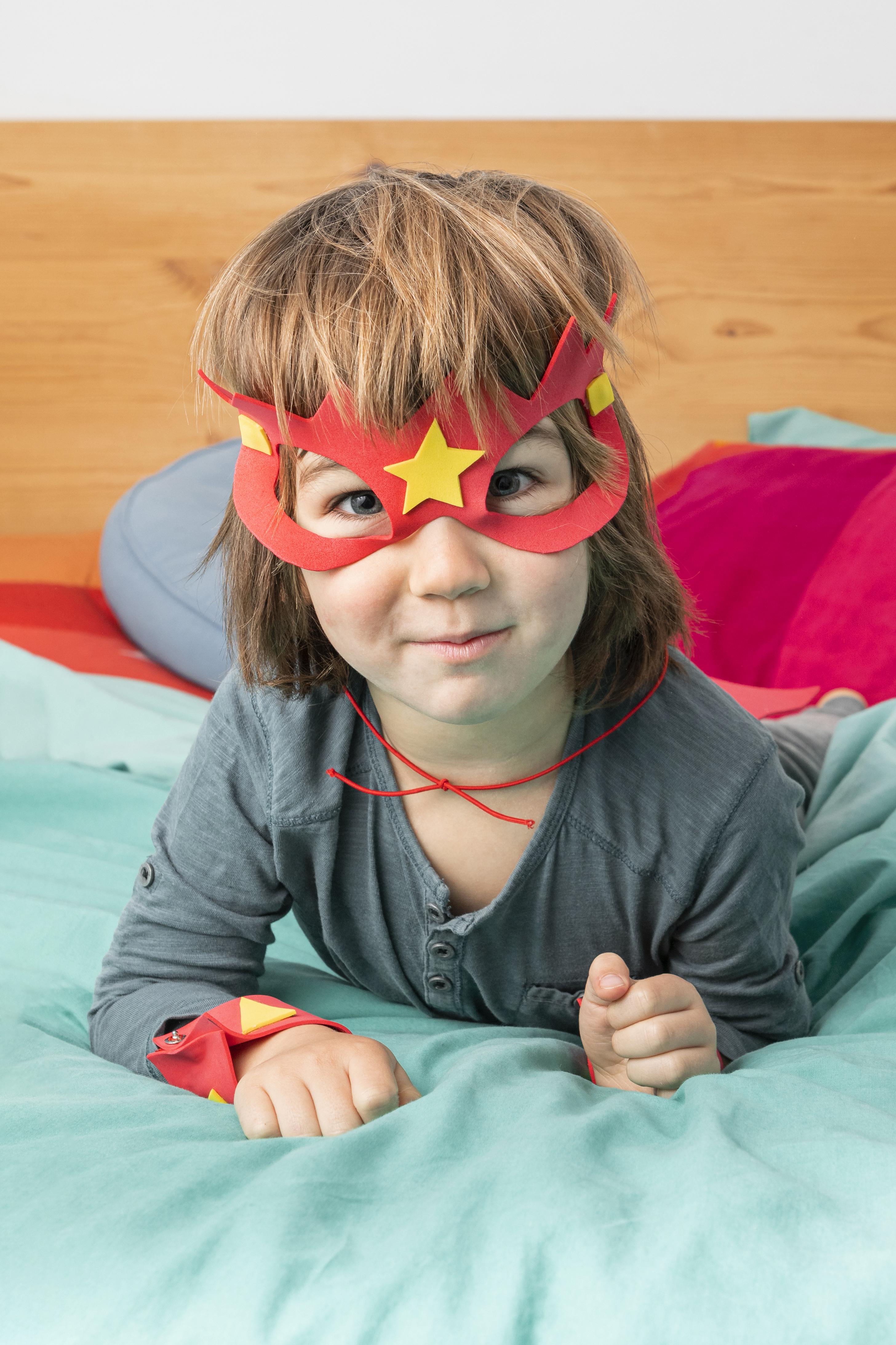 A child in superhero-themed pajamas, ready for bed