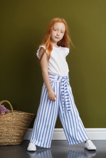 A child wearing baggy pajamas with a summery print