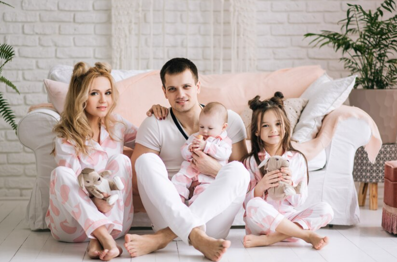 A family in matching pajamas, smiling for a group photo.