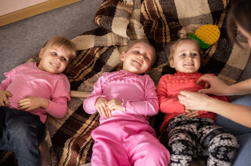 A group of kids in assorted pajamas, ready for a sleepover.