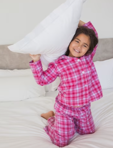 A child comfortably asleep, wearing breathable cotton pajamas.