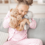 A toddler clutching a teddy bear, wearing soft cotton PJs