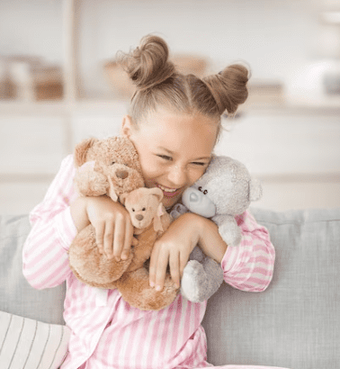 A toddler clutching a teddy bear, wearing soft cotton PJs