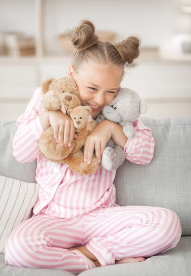 A toddler clutching a teddy bear, wearing soft cotton PJs