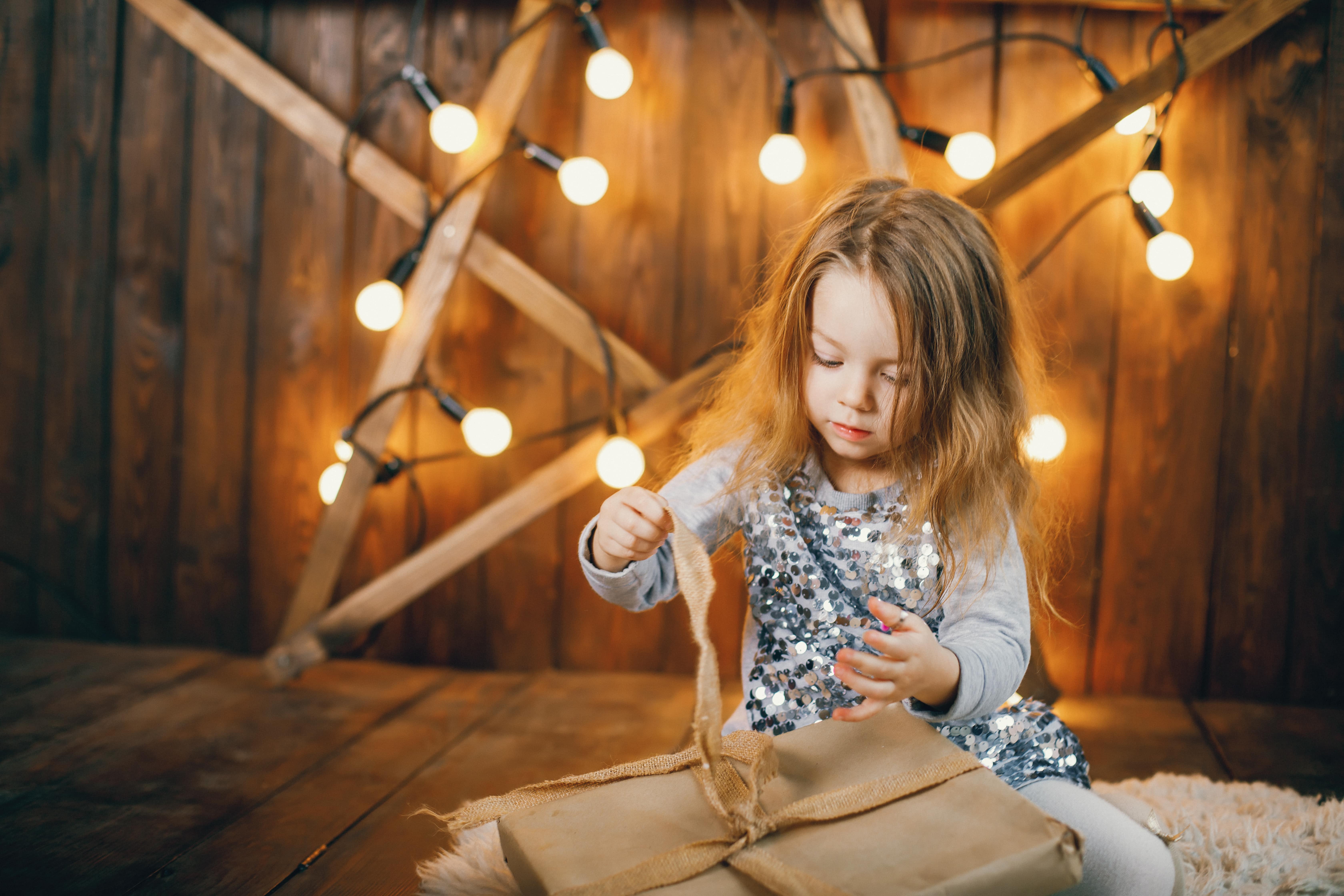 Child in star-patterned PJs, a backdrop with twinkling fairy lights