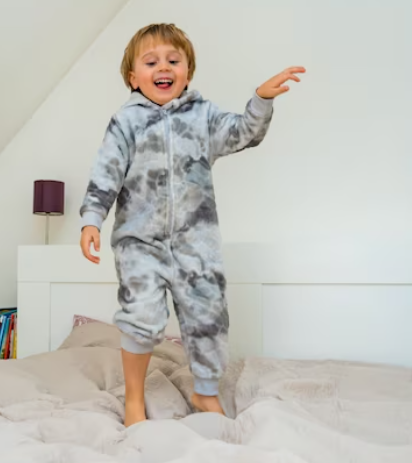 Child wearing a set of pajamas with magnetic fastenings