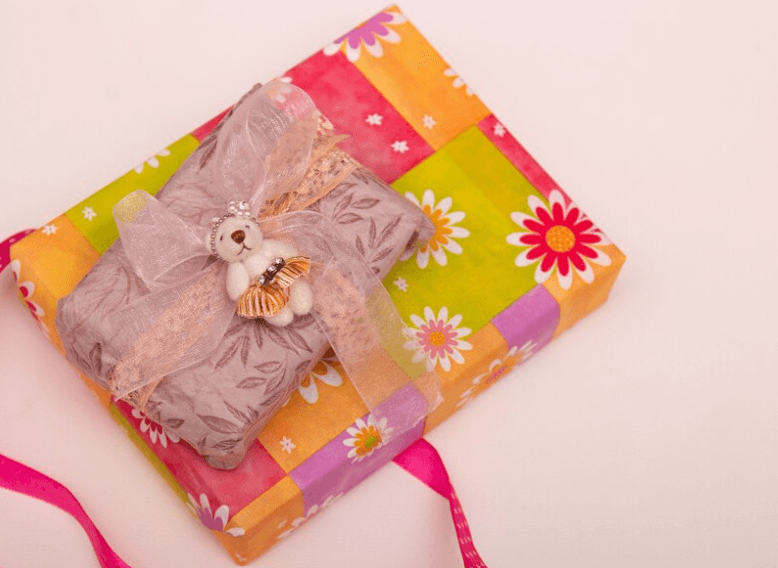 Image: Colorful wrapped gifts, with one being a folded pajama set.