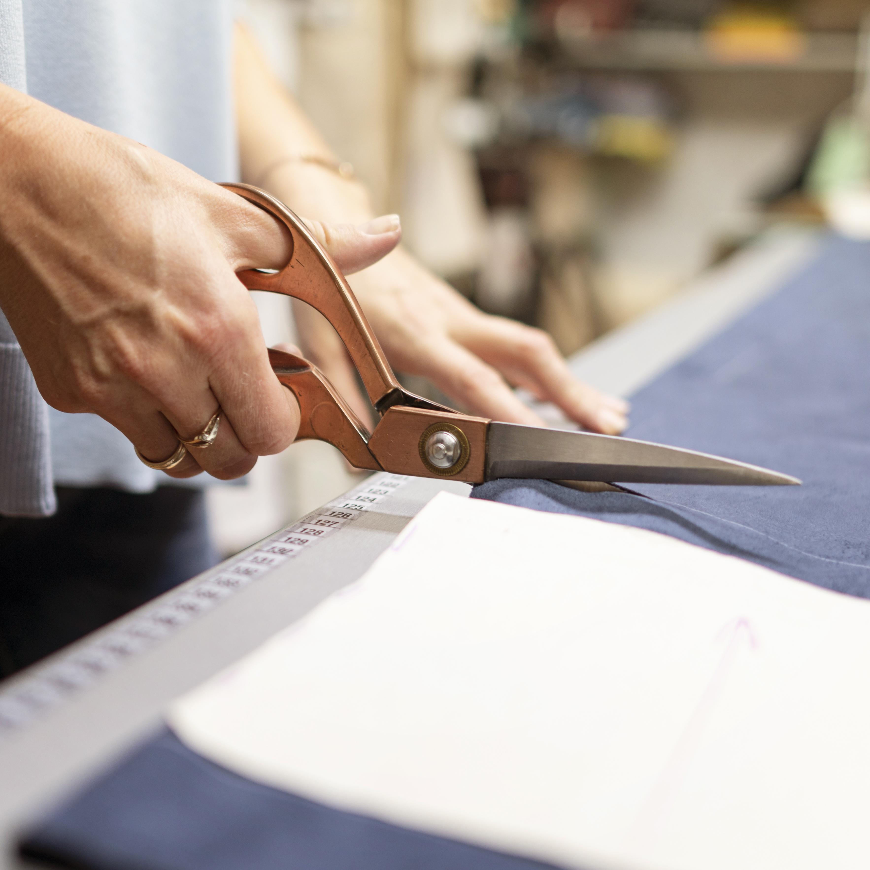 Fabric being precisely cut using large scissors