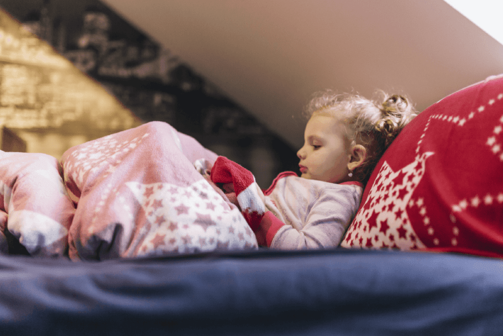 Kid comfortably sleeping in winter-themed luxurious pajamas