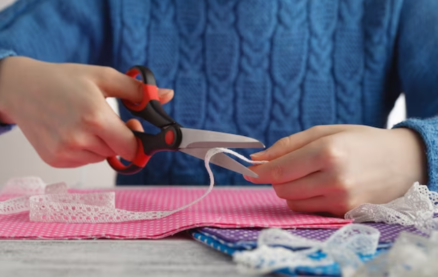 Ribbons being sewn onto the hem of pajama pants