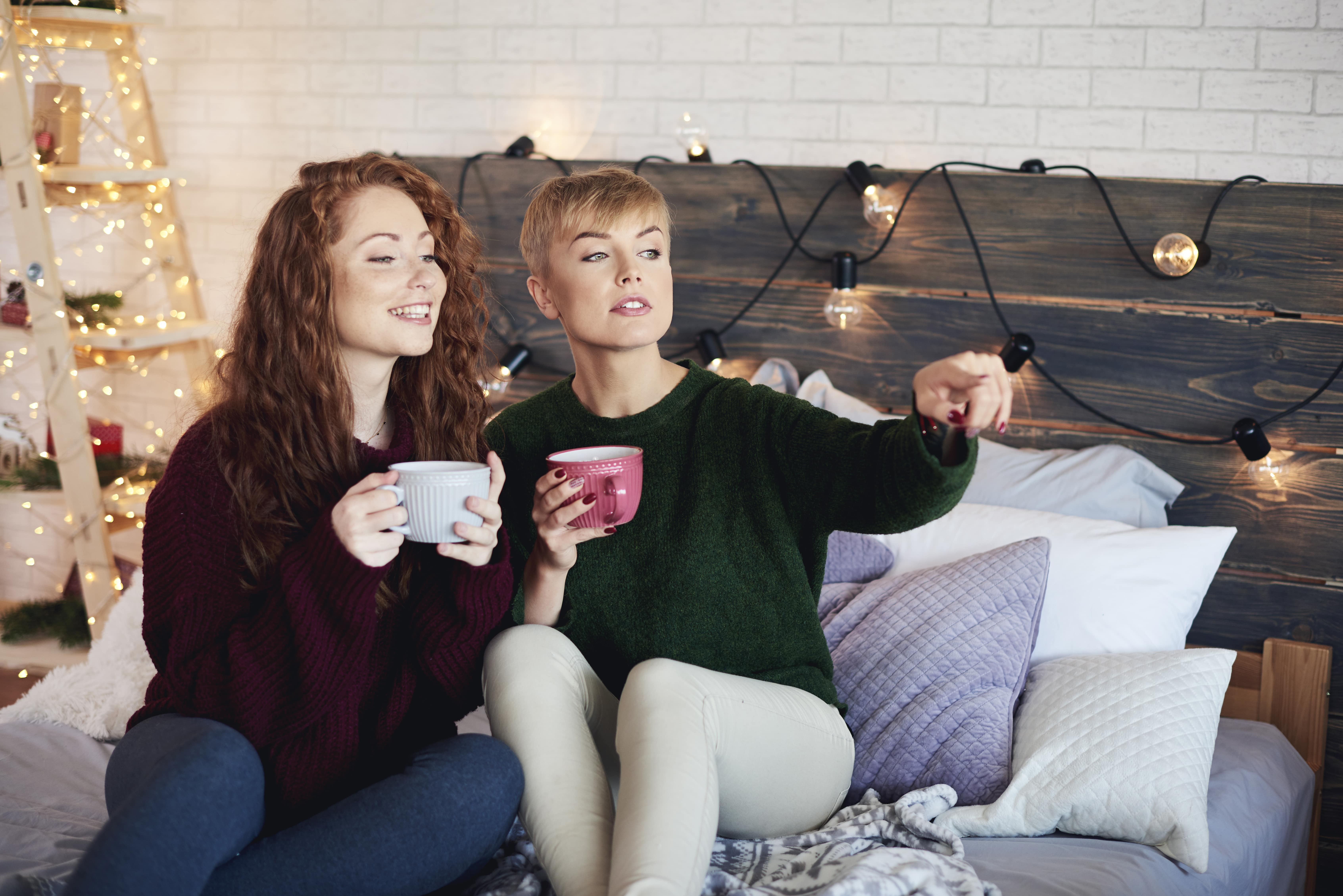 Siblings laughing and enjoying hot cocoa in their pajamas-min