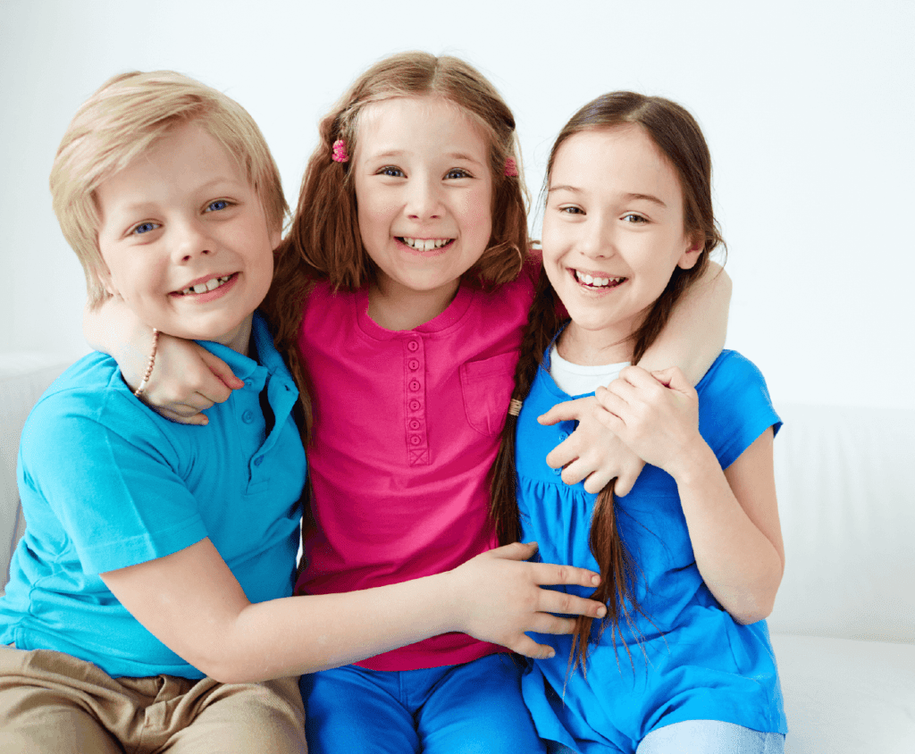 Three kids, each in uniquely colored pajamas, showcasing their styles