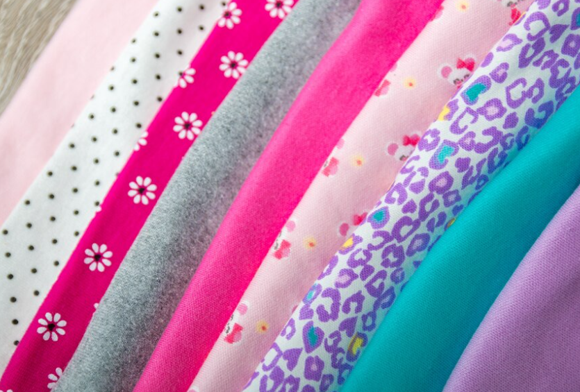 Various colorful pajama designs displayed, from polka dots to rainbow stripes