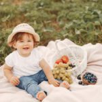 Cute little sitting on a blanket in a park